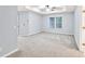 Spacious bedroom with neutral carpet, ceiling fan, and a large window for natural light at 6625 Eagle Pt, Suwanee, GA 30024