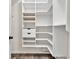 Walk-in closet with custom shelving, drawers, and ample storage space for organization at 6625 Eagle Pt, Suwanee, GA 30024