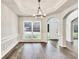 Elegant dining room with hardwood floors, wainscoting, and a modern chandelier at 6625 Eagle Pt, Suwanee, GA 30024