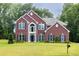 Charming brick home with manicured lawn, mature trees, and classic architectural details at 6625 Eagle Pt, Suwanee, GA 30024