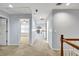 Upstairs hallway with neutral carpet and paint, open to other rooms and staircase at 6625 Eagle Pt, Suwanee, GA 30024