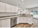 Well-lit kitchen with stainless steel dishwasher and sink with views into the main living area at 6625 Eagle Pt, Suwanee, GA 30024