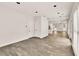 Neutral living room with recessed lighting, wood-look floors, and access to the front door at 6625 Eagle Pt, Suwanee, GA 30024