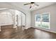 Bright living room with hardwood floors, arched doorways, and large windows for natural light at 6625 Eagle Pt, Suwanee, GA 30024
