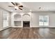Spacious living room with hardwood floors, a fireplace with built-ins, and bright windows at 6625 Eagle Pt, Suwanee, GA 30024