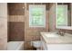 Cozy bathroom featuring a bathtub, a granite countertop vanity, and earth-toned wall tiles at 1305 Clay Sw Rd, Mableton, GA 30126
