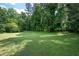 Large, green grassy yard surrounded by mature trees at 1305 Clay Sw Rd, Mableton, GA 30126