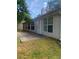 Tan home exterior featuring an entry door, concrete patio, and many large windows at 2703 Hillvale Cove Dr, Lithonia, GA 30058