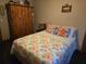 Cozy bedroom featuring a floral-themed quilt, wooden armoire, and soft, ambient lighting at 512 S Holly Springs Rd, Woodstock, GA 30188