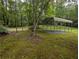 Sturdy metal carport nestled within a serene, green landscape surrounded by mature trees providing ample parking space at 512 S Holly Springs Rd, Woodstock, GA 30188