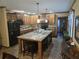 Open kitchen with custom cabinetry, stainless steel appliances, a large center island with seating, and elegant pendant lighting at 512 S Holly Springs Rd, Woodstock, GA 30188