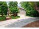 Side view of home with a two car garage and brick trimmed concrete driveway at 1558 Amberwood Creek Nw Dr, Kennesaw, GA 30152