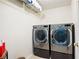Modern laundry room featuring front-load washer and dryer with overhead storage shelf at 1558 Amberwood Creek Nw Dr, Kennesaw, GA 30152