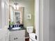 Charming powder room with granite countertop, framed mirror and view to the living room at 1558 Amberwood Creek Nw Dr, Kennesaw, GA 30152