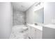 Bathroom with marble-look tile, modern shower, and updated vanity at 3042 Monterey Dr, Decatur, GA 30032