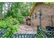 Brick house back exterior featuring a charming arbor and green landscape at 3206 Pyrite Sw Cir, Atlanta, GA 30331