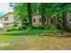 View of a home partially hidden by mature trees, featuring brick and siding at 3206 Pyrite Sw Cir, Atlanta, GA 30331