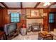 Wood-paneled living room with a brick fireplace, window, vintage entertainment center, and wooden ceiling beams at 3206 Pyrite Sw Cir, Atlanta, GA 30331