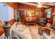 Wood-paneled living room with a comfortable sofa, fireplace, piano, and entertainment center, creating a cozy atmosphere at 3206 Pyrite Sw Cir, Atlanta, GA 30331