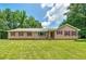 Inviting ranch-style home featuring a large lawn, complemented by charming red window shutters at 35 Brookside Ct, Villa Rica, GA 30180