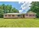 Inviting ranch-style home featuring a large lawn, complemented by charming red window shutters at 35 Brookside Ct, Villa Rica, GA 30180