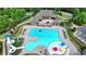 Aerial view of a pool with a slide, splash pad, and clubhouse, perfect for summer fun and relaxation at 4590 Sierra Creek Dr, Hoschton, GA 30548