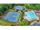 Aerial view of the community pool, tennis courts, and clubhouse surrounded by lush greenery at 4590 Sierra Creek Dr, Hoschton, GA 30548