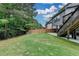 Lush backyard with privacy fence and stairs leading to a deck area, with mature trees along the back at 4590 Sierra Creek Dr, Hoschton, GA 30548