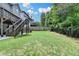 Expansive backyard with lush lawn, wooden privacy fence, and deck access stairs at 4590 Sierra Creek Dr, Hoschton, GA 30548