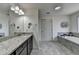 Bathroom with a dual vanity, granite counters, soaking tub, and modern fixtures at 4590 Sierra Creek Dr, Hoschton, GA 30548