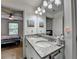 Bathroom featuring double sinks, granite countertops, and modern lighting, offering both functionality and style at 4590 Sierra Creek Dr, Hoschton, GA 30548