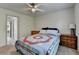 Cozy bedroom with a ceiling fan, a comfortable bed with a colorful quilt, and classic wooden dressers at 4590 Sierra Creek Dr, Hoschton, GA 30548