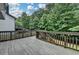 Wooden deck featuring railing, stairs to backyard, and mature trees in the background at 4590 Sierra Creek Dr, Hoschton, GA 30548