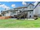 Rear exterior view of a gray two-story home, showcasing the deck, patio, and landscaped backyard at 4590 Sierra Creek Dr, Hoschton, GA 30548