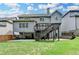 Rear exterior view of a gray two-story home, featuring the deck, patio, and landscaped backyard at 4590 Sierra Creek Dr, Hoschton, GA 30548