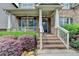 Charming front porch with brick stairs, white railings, and well-maintained landscaping at 4590 Sierra Creek Dr, Hoschton, GA 30548