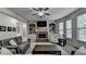 Spacious living room with a brick fireplace, built-in shelves, and large windows providing natural light at 4590 Sierra Creek Dr, Hoschton, GA 30548