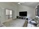 Spacious living area featuring a large TV, comfortable seating, and an open doorway to another area at 4590 Sierra Creek Dr, Hoschton, GA 30548