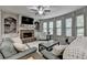 Comfortable living room with a cozy fireplace, built-in shelving, large windows and plenty of seating at 4590 Sierra Creek Dr, Hoschton, GA 30548
