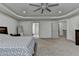 Large main bedroom featuring tray ceiling, large window, and en suite bathroom and walk-in closet access at 4590 Sierra Creek Dr, Hoschton, GA 30548