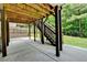 Under-deck patio featuring wood columns, an outdoor area, and a lush green backyard at 4590 Sierra Creek Dr, Hoschton, GA 30548