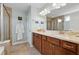 Bathroom featuring double sinks with a granite countertop, framed mirror, and a glass-enclosed shower with tile walls at 506 Spring View Dr, Woodstock, GA 30188