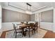 Formal dining room with modern chandelier, wainscoting, and a neutral color palette at 506 Spring View Dr, Woodstock, GA 30188