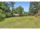 Expansive grassy backyard with mature trees and a partial view of the back of the house at 11473 Summer Creek Dr, Hampton, GA 30228