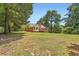 Back of home featuring brick facade, large lawn, a wooden deck and mature trees and shrubbery at 11473 Summer Creek Dr, Hampton, GA 30228