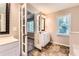 Bright bathroom featuring a vanity with sink, decorative mirror, and stylish tiled flooring at 11473 Summer Creek Dr, Hampton, GA 30228
