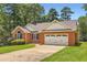 Charming brick home with a well-manicured lawn and attached two car garage at 11473 Summer Creek Dr, Hampton, GA 30228