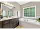 Modern bathroom featuring a soaking tub, dark wood cabinets, granite countertop and walk-in shower at 1223 Gathering Oaks Se Ct, Mableton, GA 30126