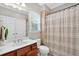Neutral bathroom featuring a vanity, toilet, and shower-tub combination with curtain and natural light at 1223 Gathering Oaks Se Ct, Mableton, GA 30126