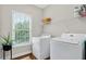 This laundry room features white appliances, hardwood floors, and a bright window at 1223 Gathering Oaks Se Ct, Mableton, GA 30126